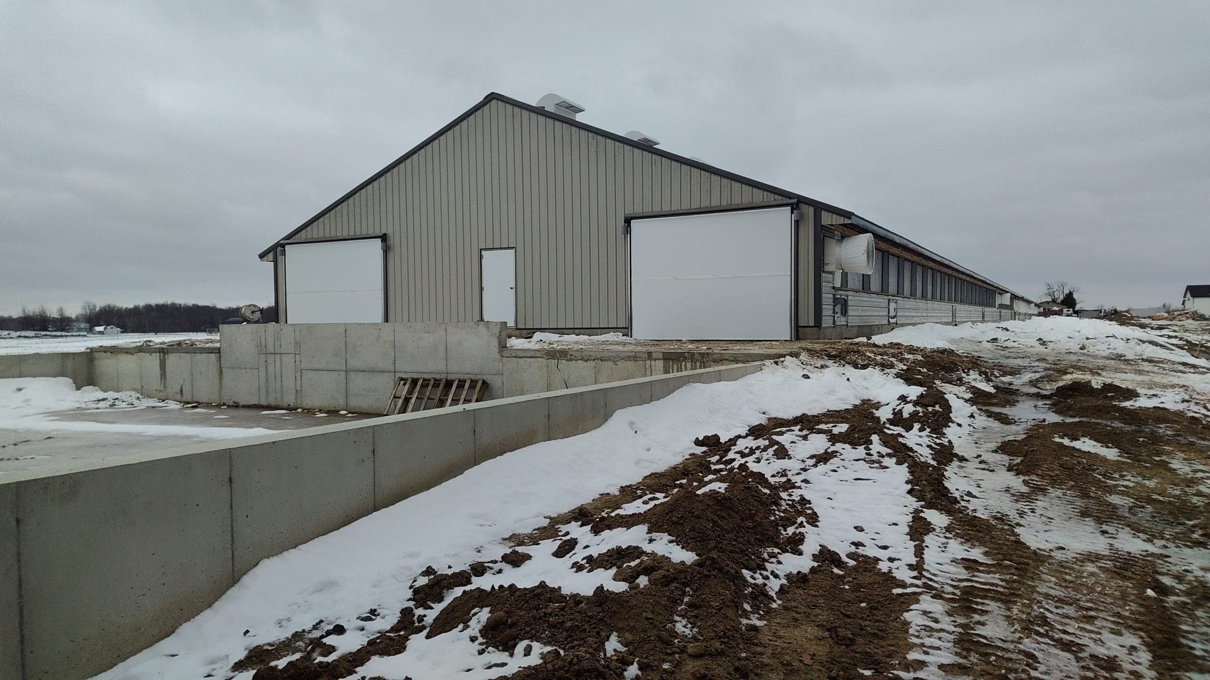 Agricultural barn with concrete loading ramp and large bay doors in Northern Indiana winter