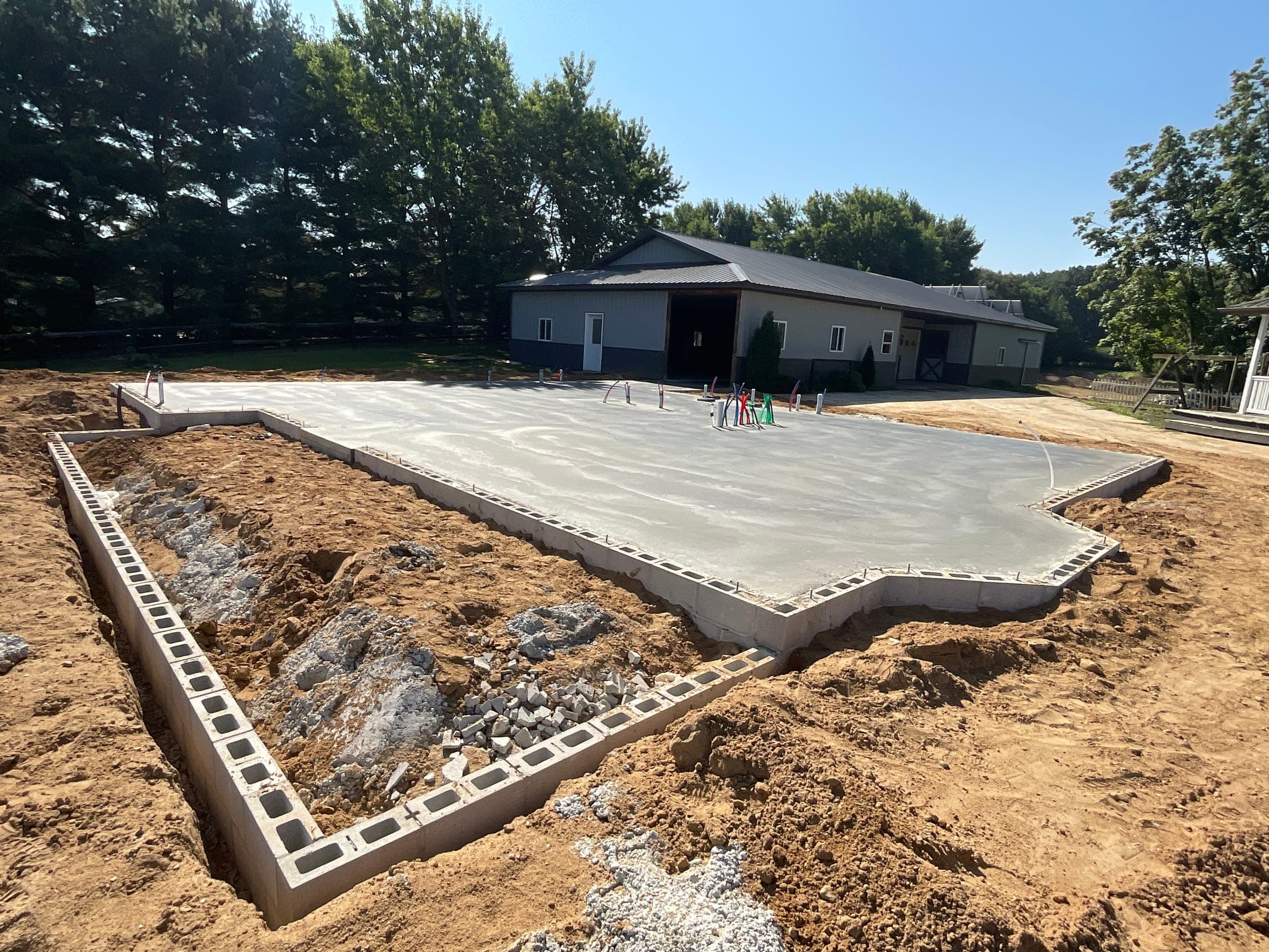 Cinder block foundation walls and concrete slab for new build by Starlite Builders