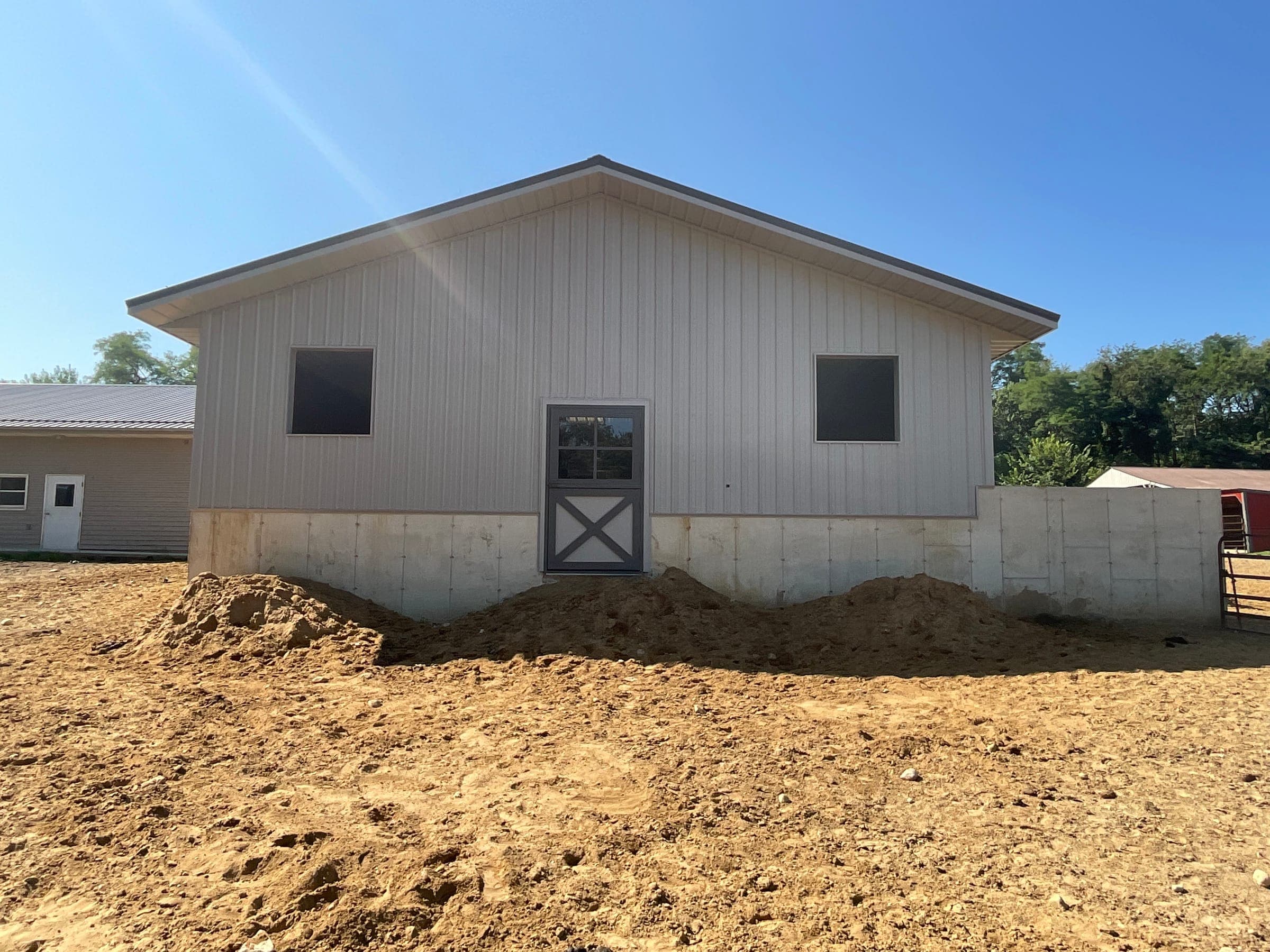 Finished horse barn gable end with dutch door and metal siding built by Starlite Builders