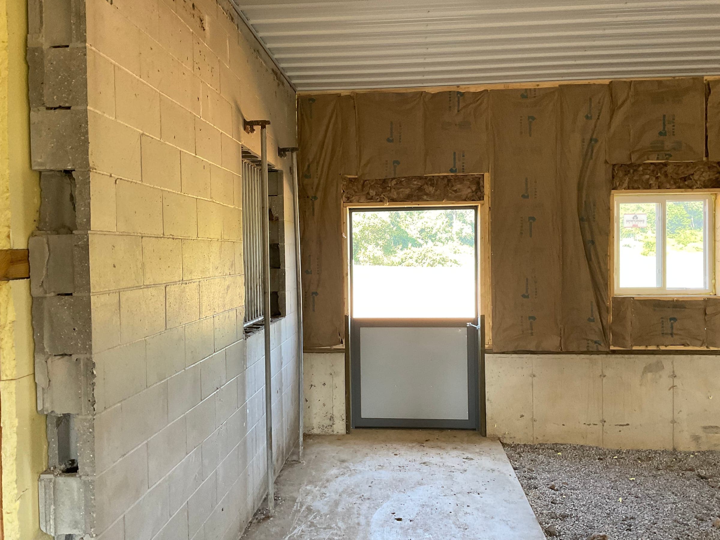 Horse barn interior showing cinder block wall and dutch door during construction