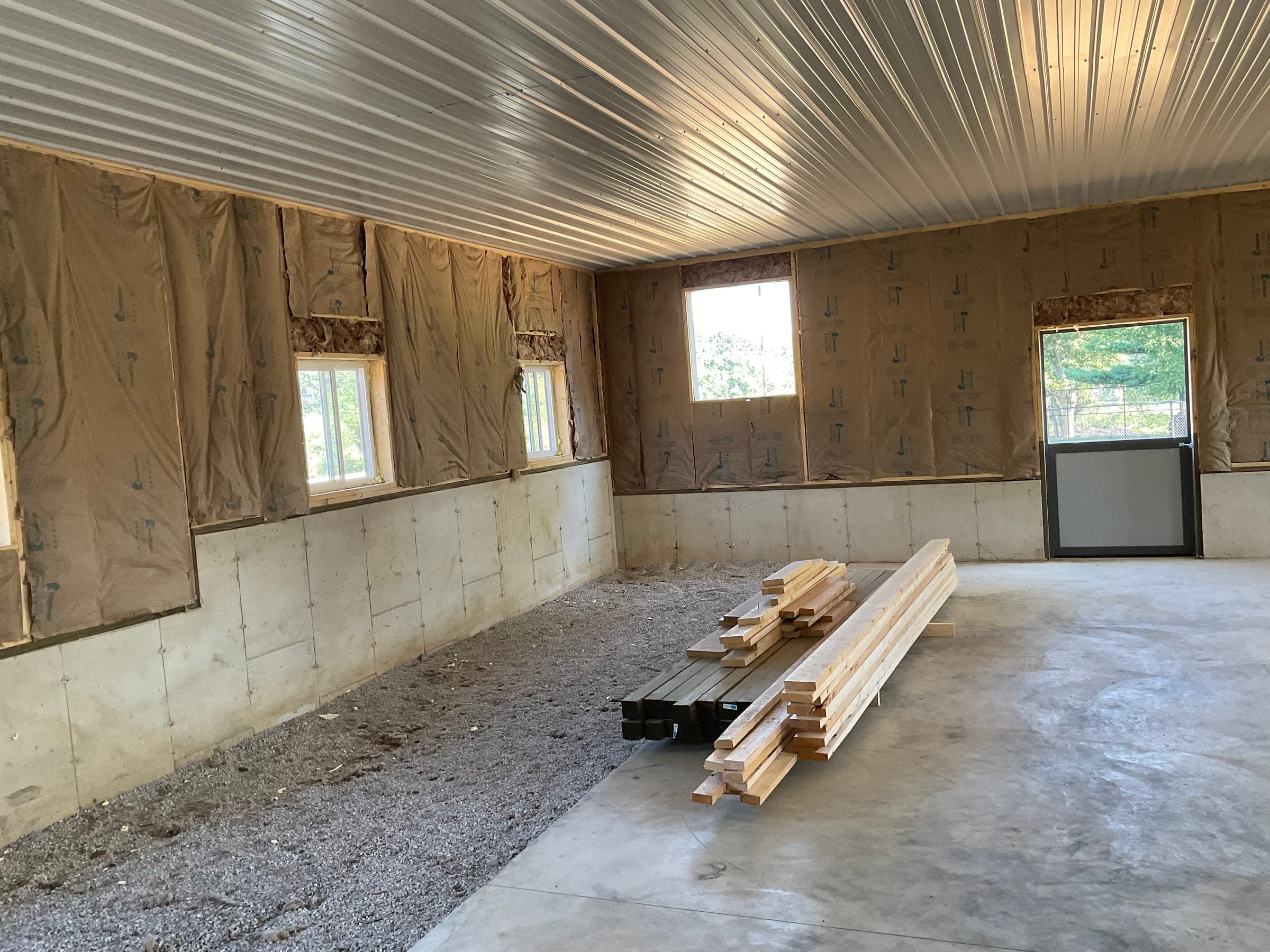 Horse barn interior with insulation and lumber materials during construction