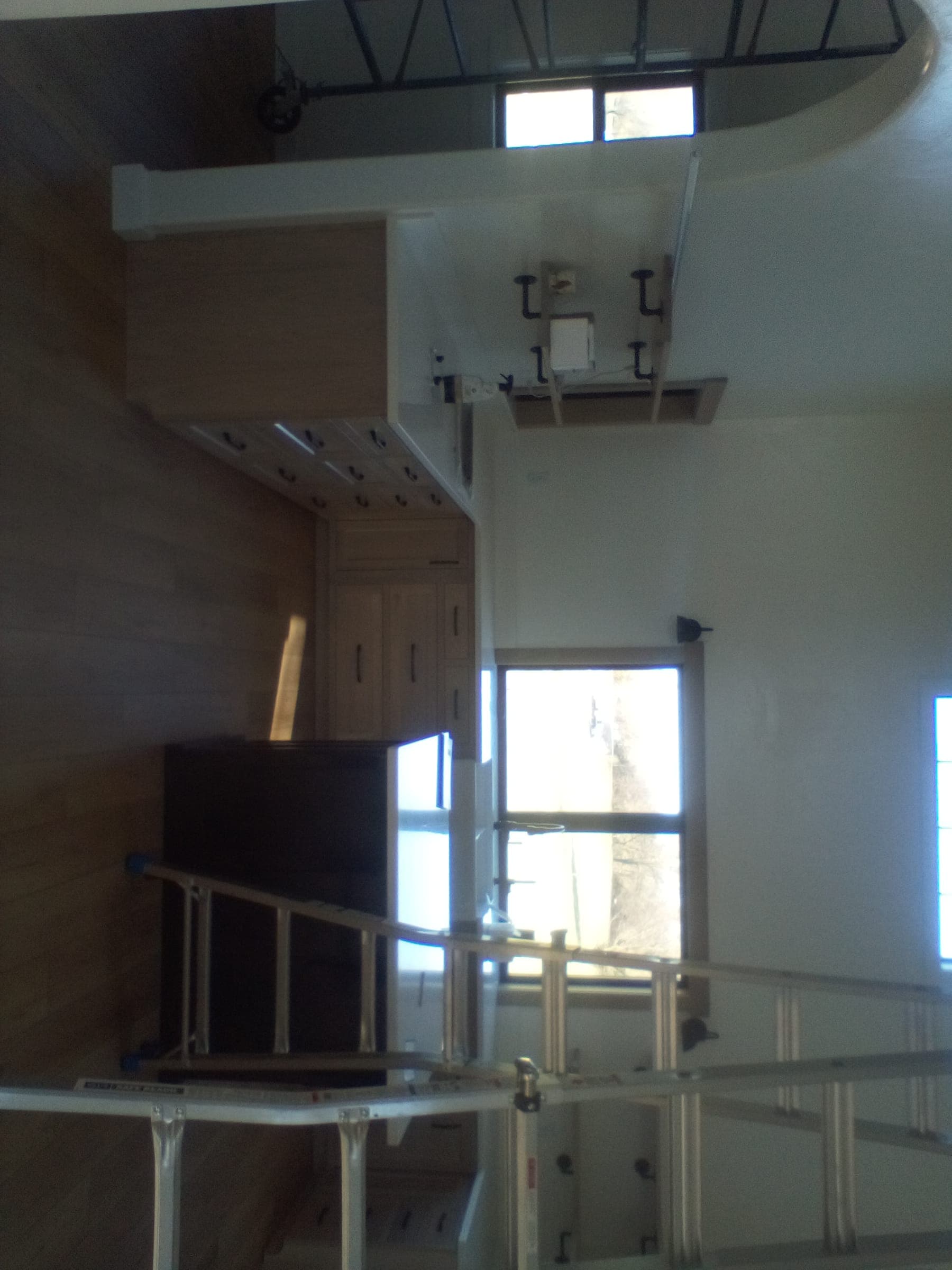 Interior of custom farmhouse under construction showing tall open stairwell and scaffolding