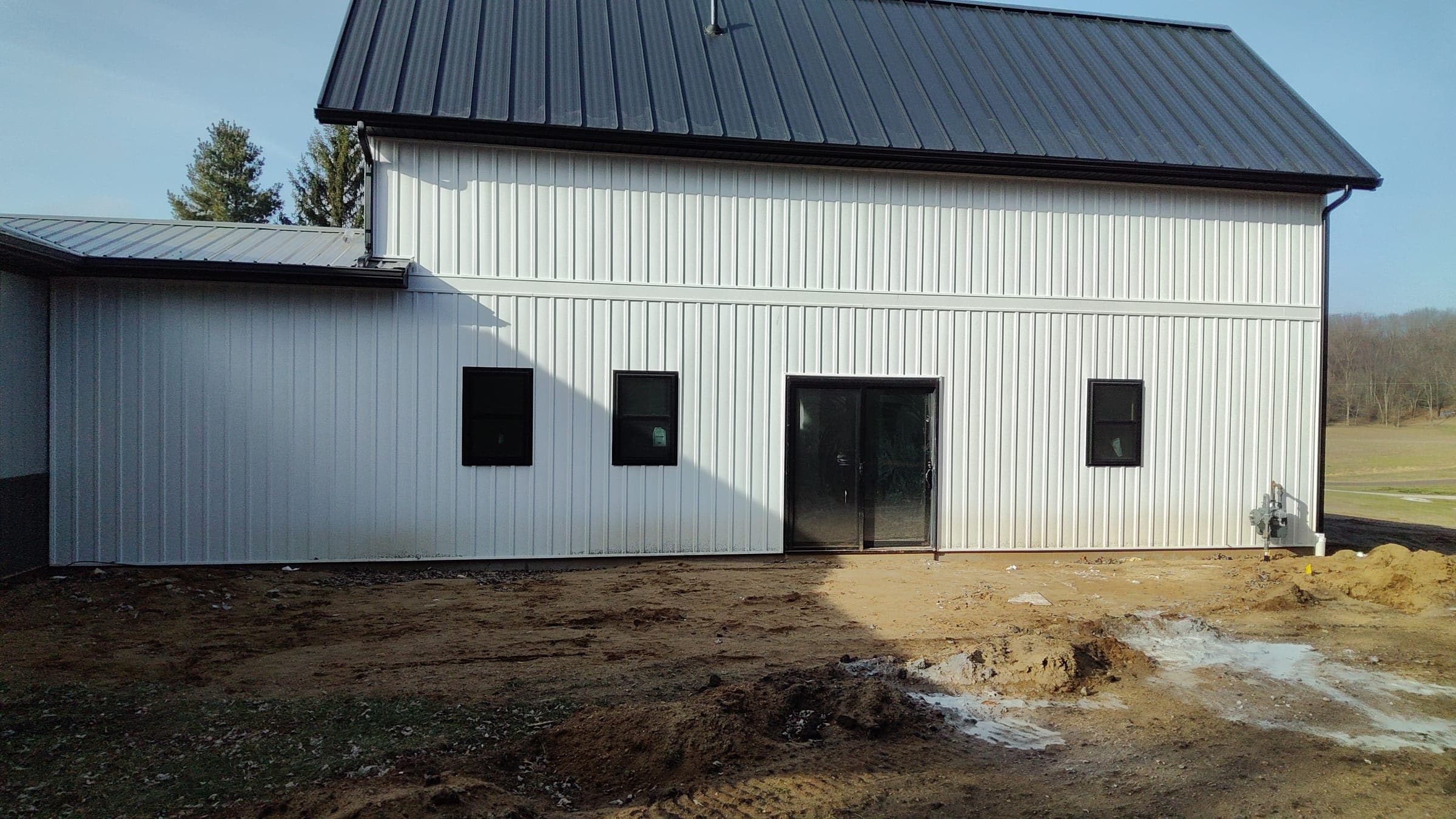 Attached workshop or garage with double doors and three windows on custom farmhouse